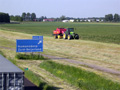 In mei waren wij druk bezig om al het gras in te kuilen en in folie te wikkelen. Zoals u hier ziet: aan de rijksweg A29. Gezien het weer moest alles in korte tijd gebeuren, maar dit was uiteraard geen probleem. (Mei 2005)